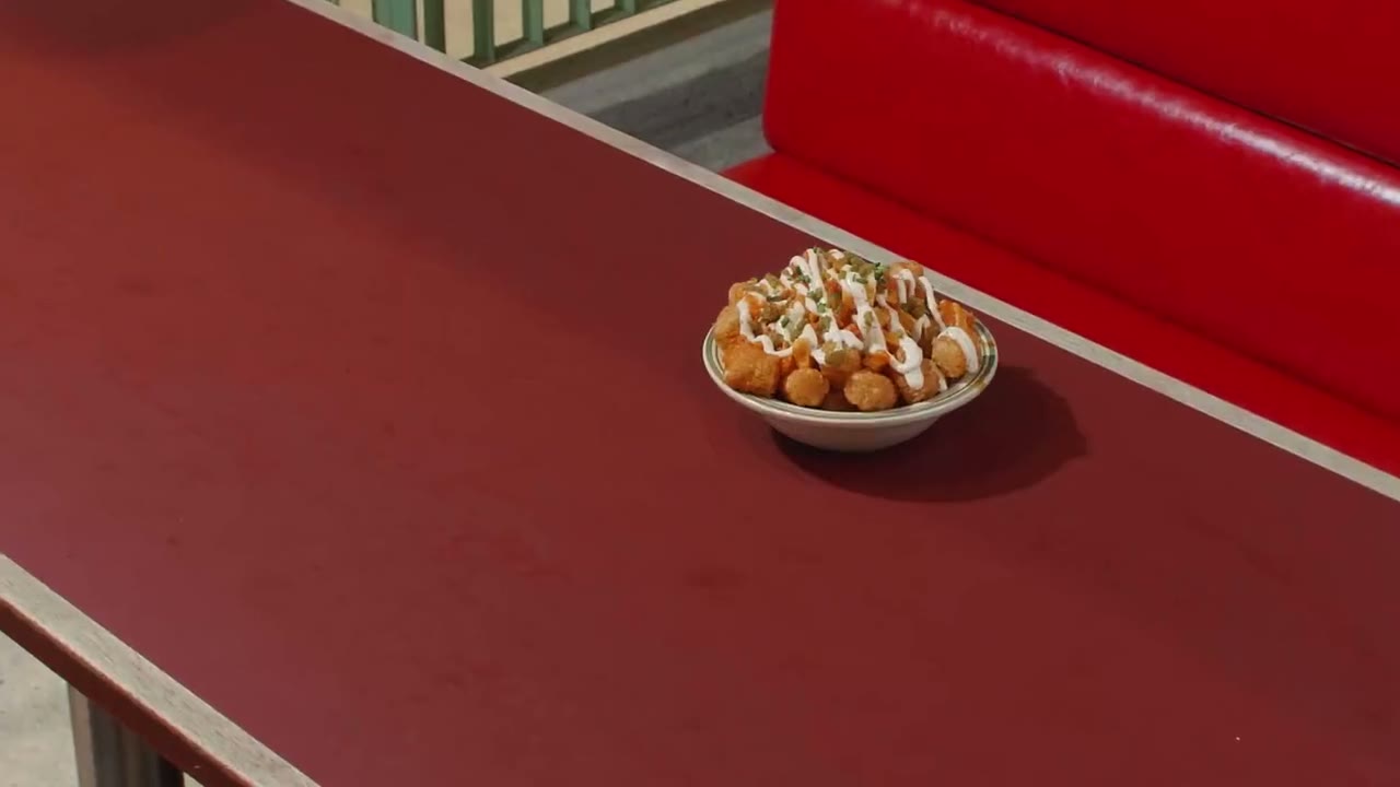 An empty red booth at The Campus fills with plates of tots, nachos, salads and fried chicken, then friends crowd round the table and share it